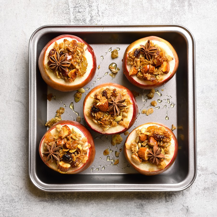 Red Baked Apples With Granola, Cinnamon, Nuts And Honey On Stone Background. Healthy Fruit Dessert. 