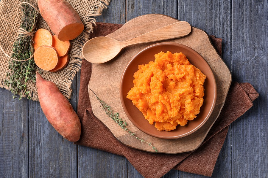 Composition with mashed sweet potato on wooden background